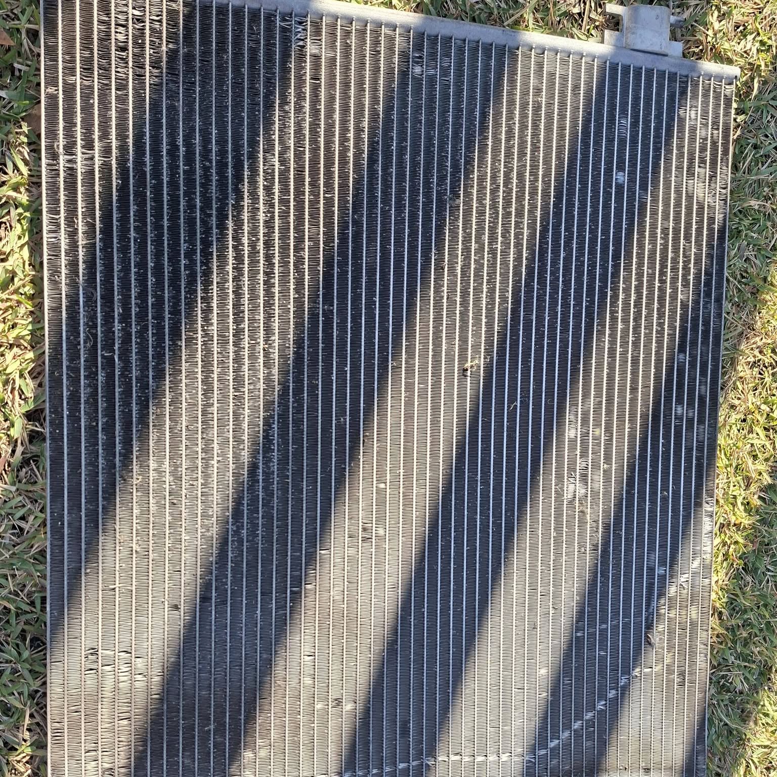 New air conditioning condenser laid out on grass