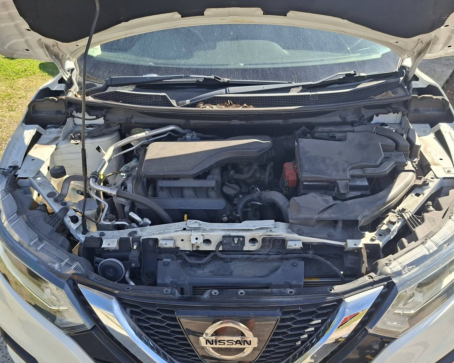 Nissan Qashqai with the bonnet up mid job on a grass verge